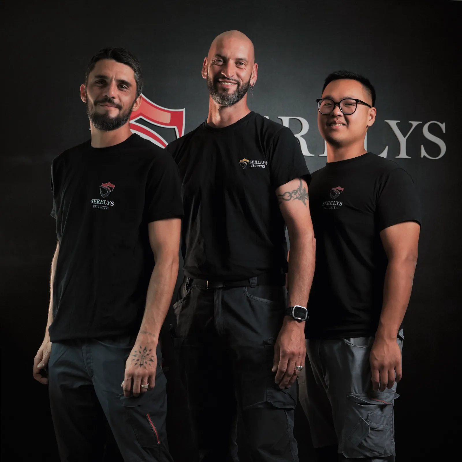 Équipe de trois professionnels SERELYS SÉCURITÉ en Vendée portant des t-shirts noirs avec logo, experts en vidéosurveillance et solutions de sécurité