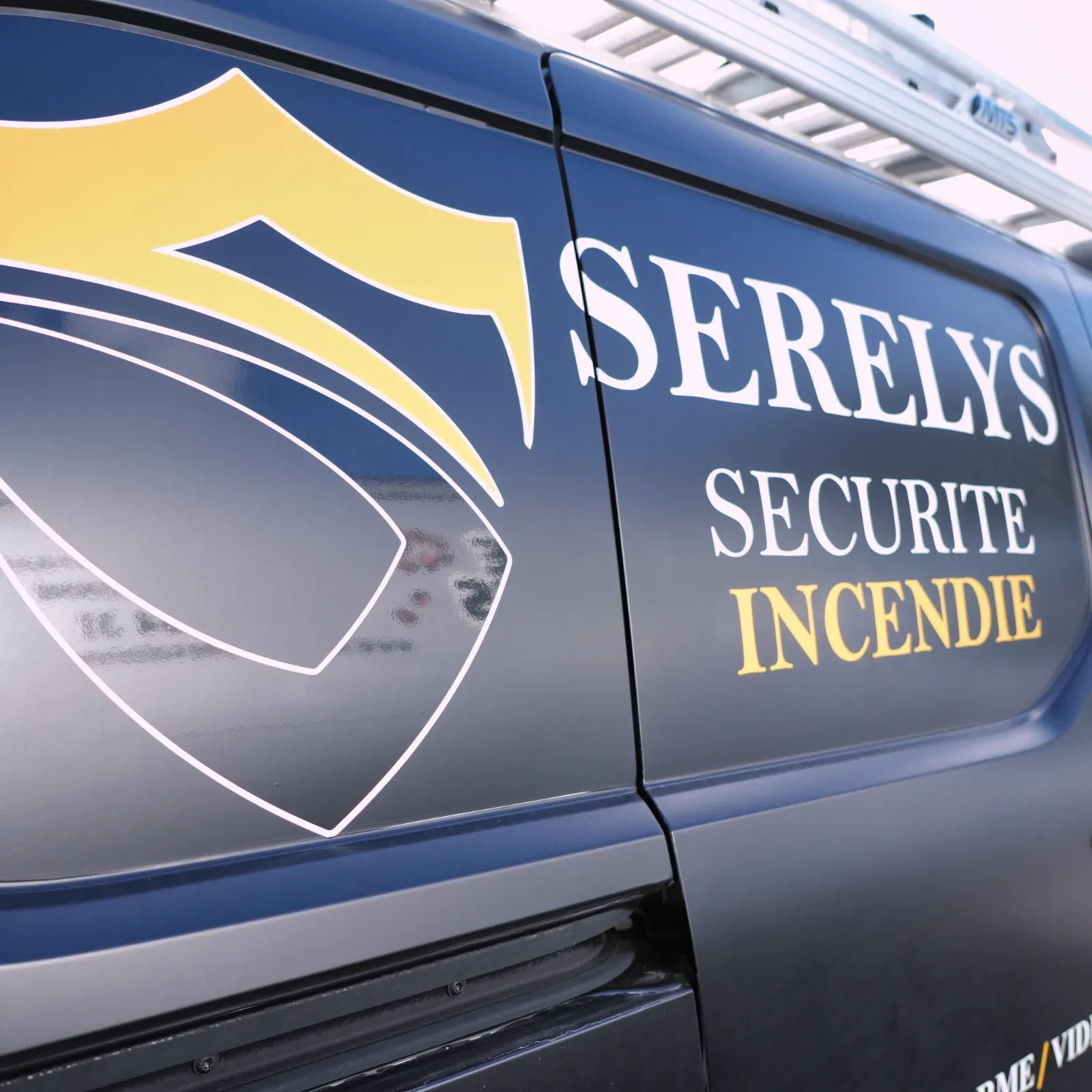 Véhicule de SERELYS SÉCURITÉ en Vendée avec logo bleu et jaune, spécialisé en vidéosurveillance et solutions de sécurité incendie