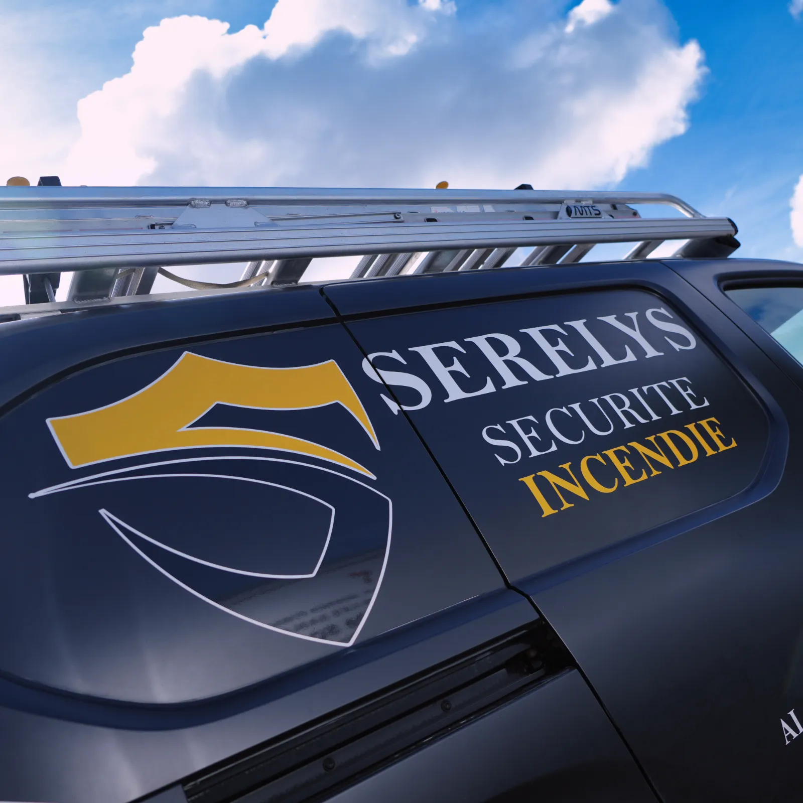 Véhicule de service SERELYS SÉCURITÉ en Vendée avec galerie de toit aluminium, logo doré et blanc, spécialisé en vidéosurveillance et solutions de sécurité