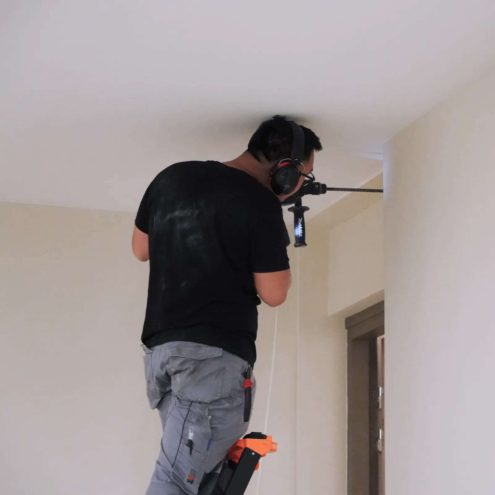 Technicien SERELYS SÉCURITÉ en Vendée effectuant l'installation d'une caméra de vidéosurveillance au plafond avec équipement professionnel de sécurité