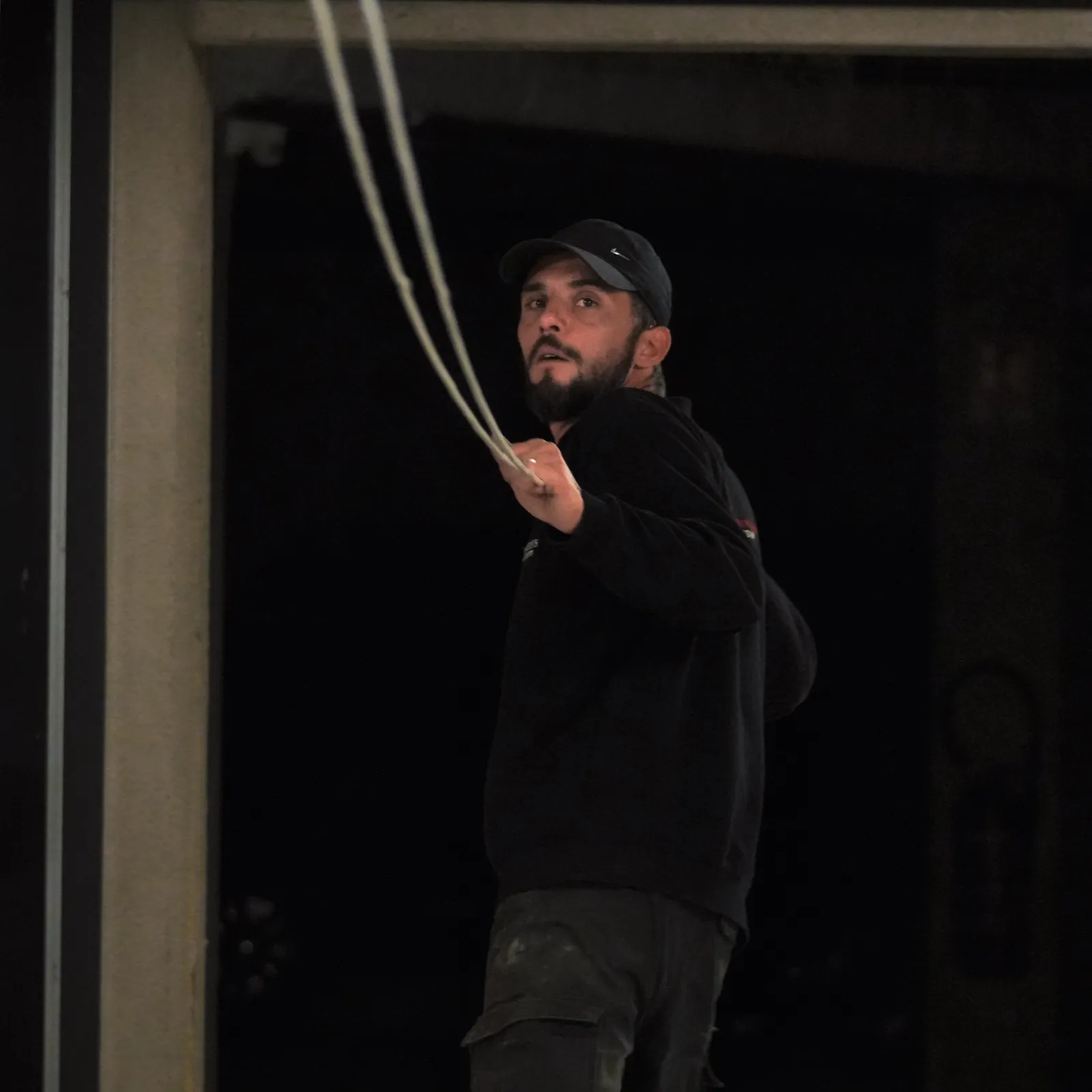 Technicien SERELYS SÉCURITÉ en Vendée effectuant une installation de vidéosurveillance nocturne, manipulant un câble de sécurité professionnel