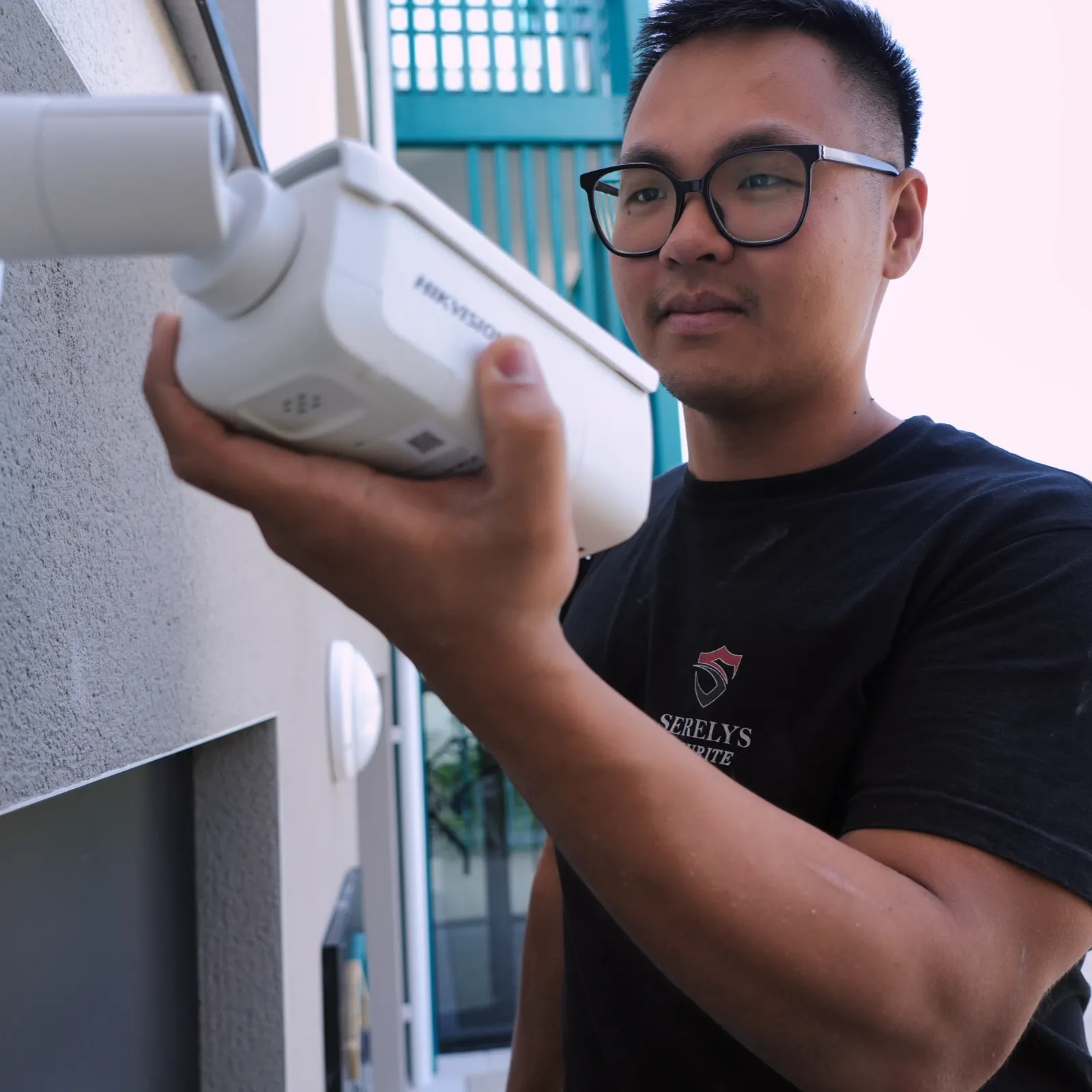 Technicien SERELYS SÉCURITÉ en Vendée installant une caméra de vidéosurveillance IP professionnelle en extérieur sur façade