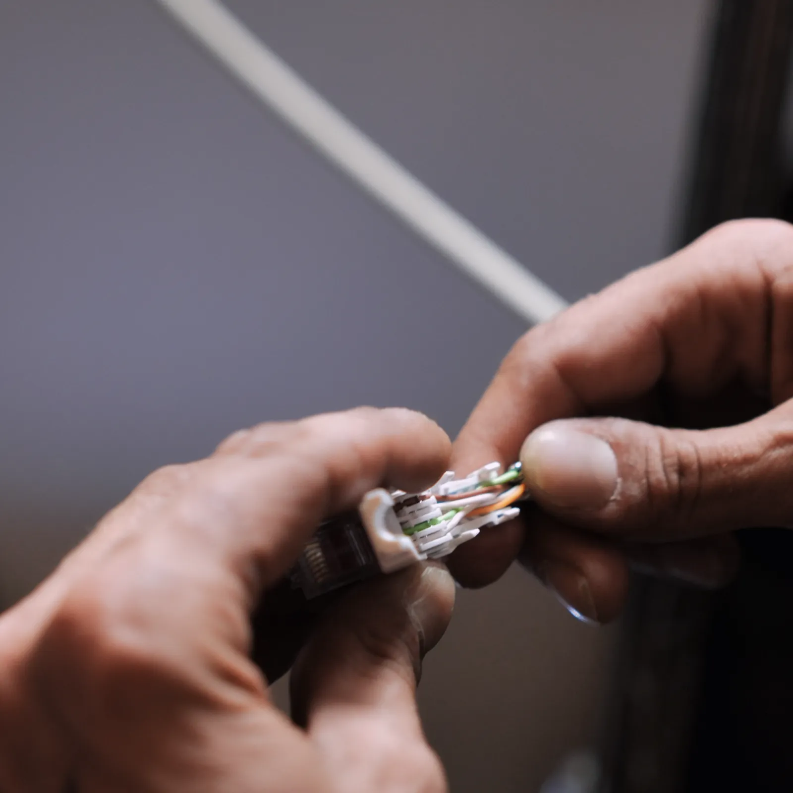 Technicien SERELYS SÉCURITÉ en Vendée effectuant l'installation d'un câble réseau pour système d'alarme intrusion sur mesure premium
