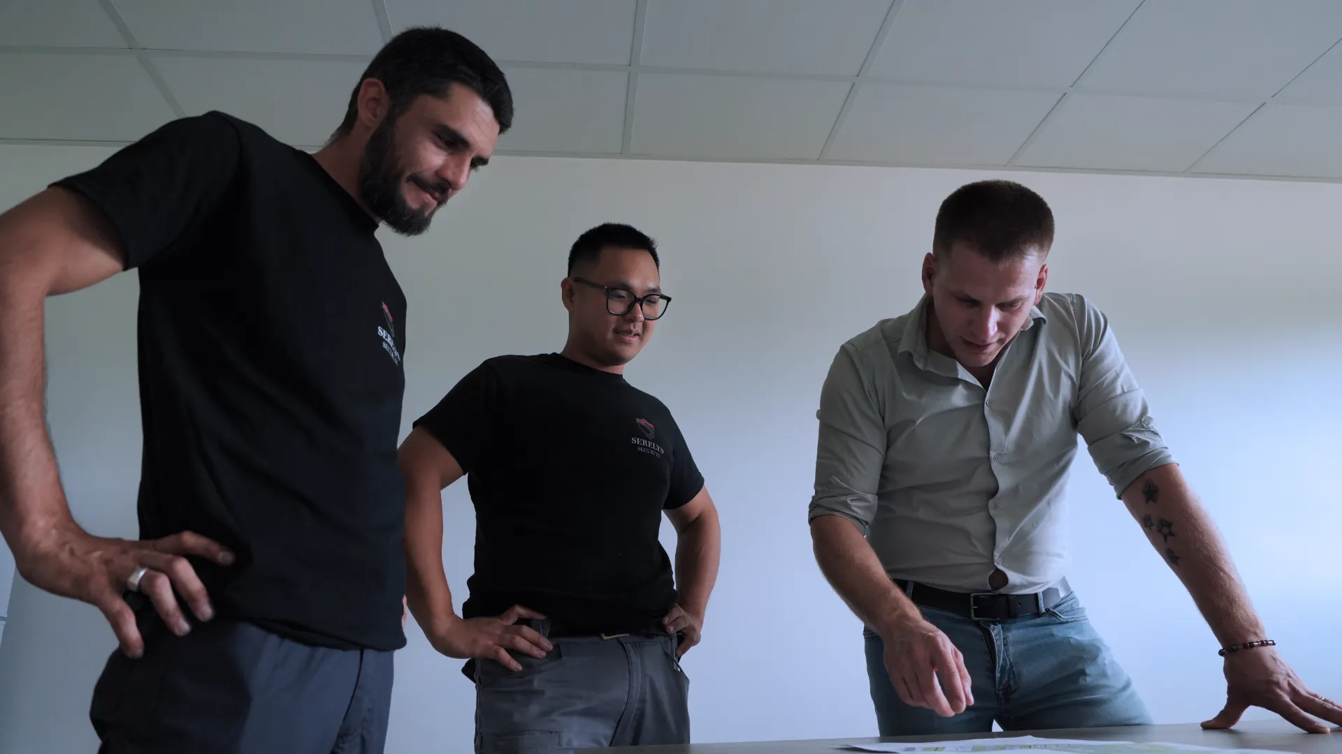 Équipe SERELYS SÉCURITÉ en Vendée lors d'une réunion technique de vidéosurveillance, trois professionnels discutent autour d'une table blanche