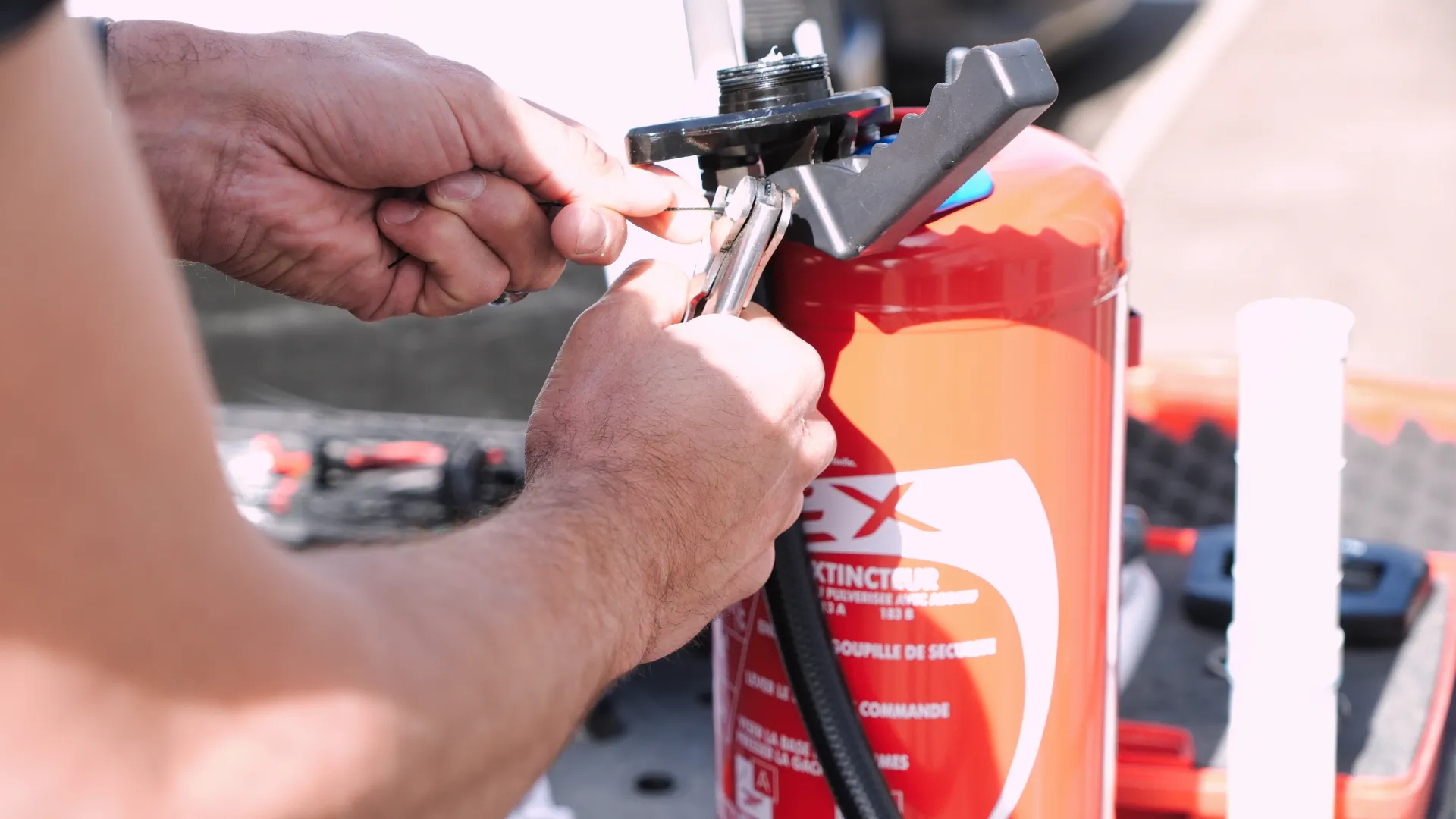 Technicien de SERELYS SÉCURITÉ en Vendée effectuant la maintenance d'un extincteur, démontrant l'expertise en solutions de sécurité incendie et prévention des risques
