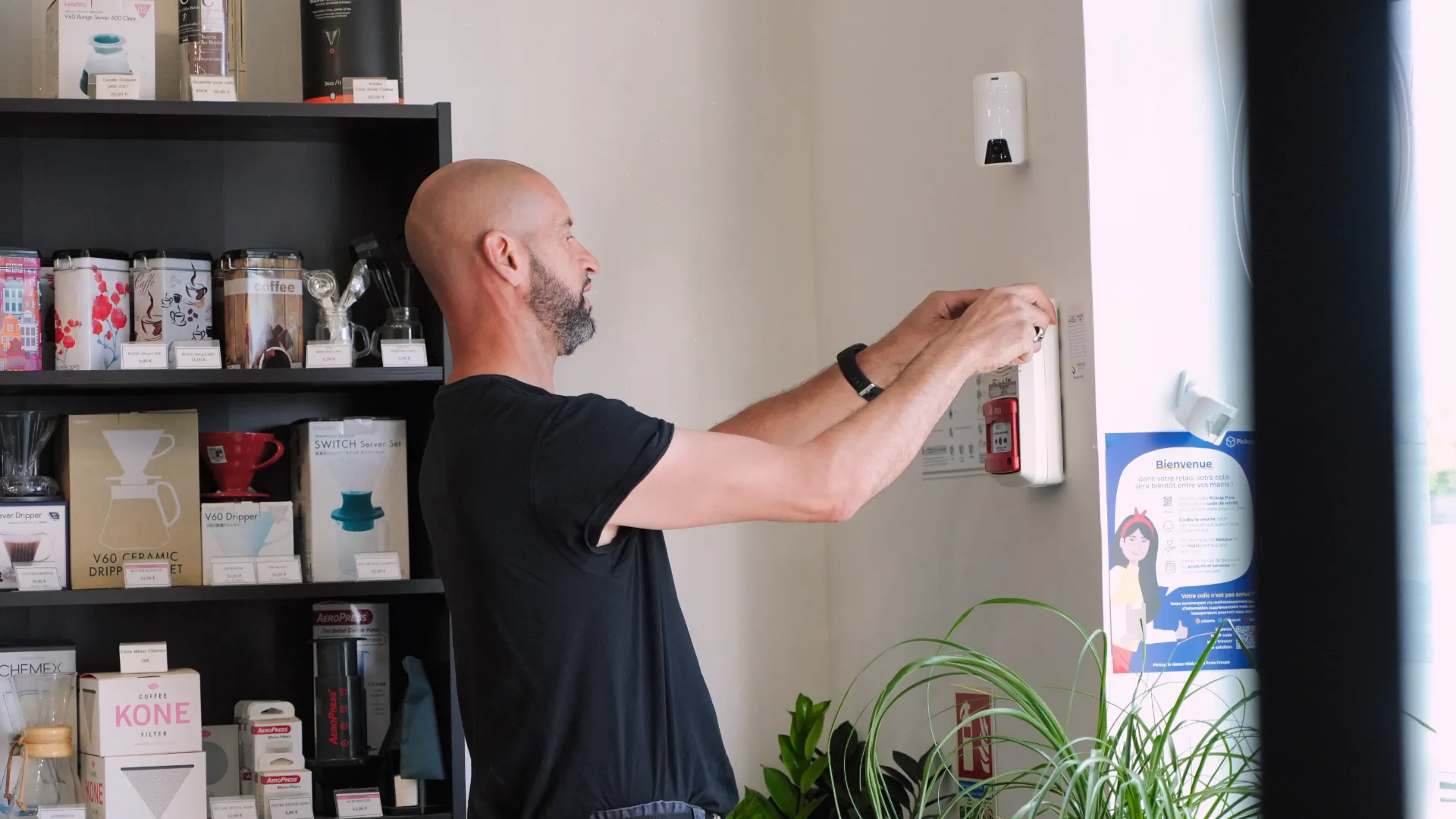 Technicien SERELYS SÉCURITÉ en Vendée installe un dispositif de vidéosurveillance mural dans un local commercial, démontrant son expertise en solutions de sécurité