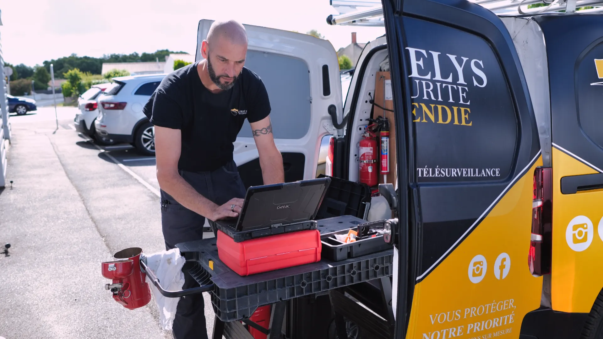 Technicien SERELYS SÉCURITÉ en Vendée installant une solution de vidéosurveillance depuis son véhicule équipé, mallette de diagnostic et outils visibles