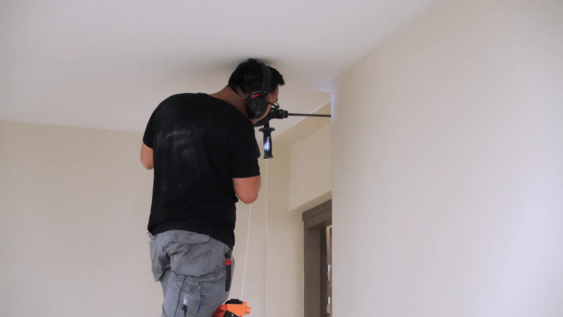 Technicien SERELYS SÉCURITÉ en Vendée installant un système de détection intrusion au plafond avec équipement professionnel de sécurité