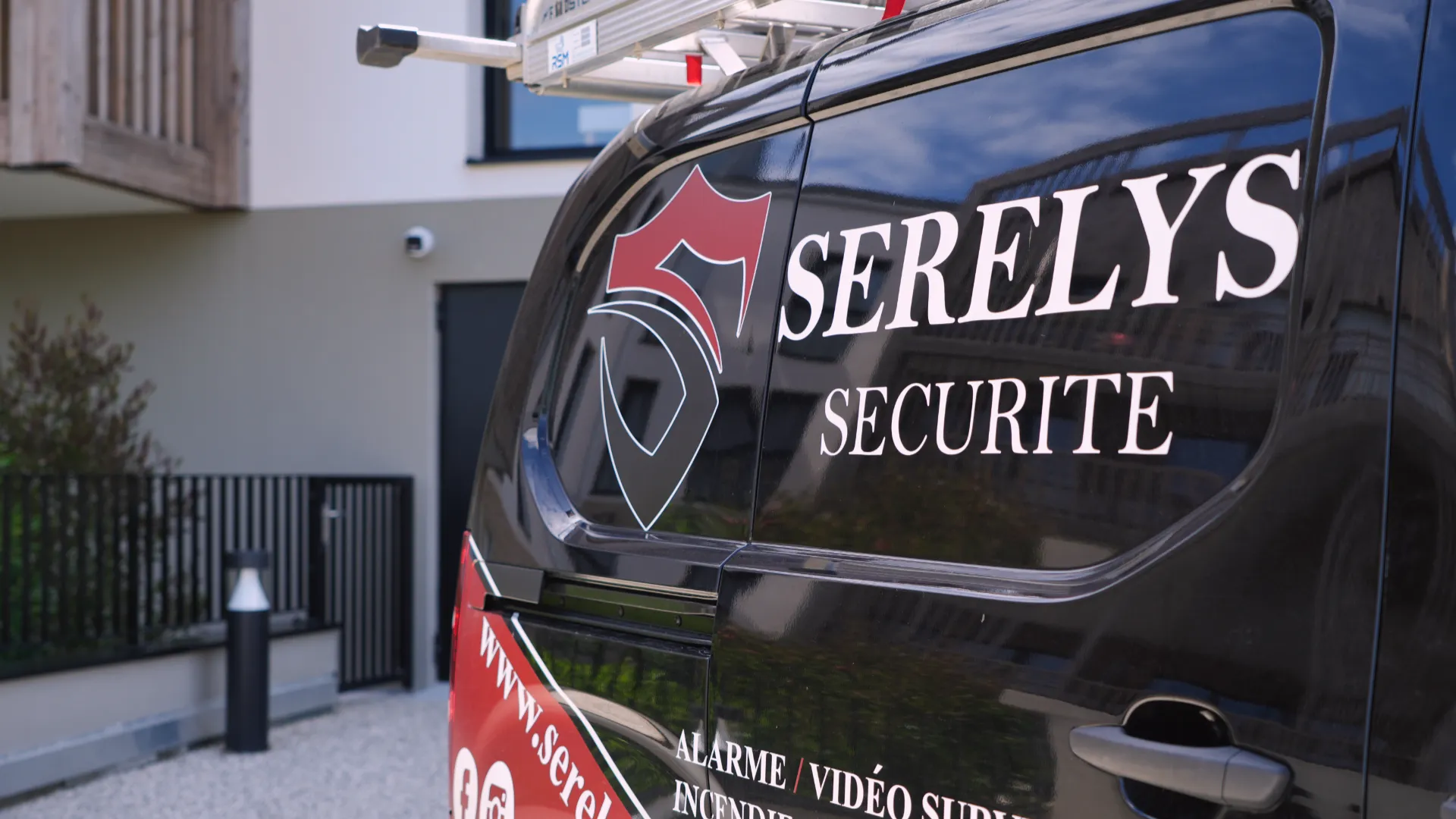 Véhicule noir de SERELYS SÉCURITÉ en Vendée avec logo rouge et blanc, spécialisé en vidéosurveillance et solutions de sécurité professionnelles