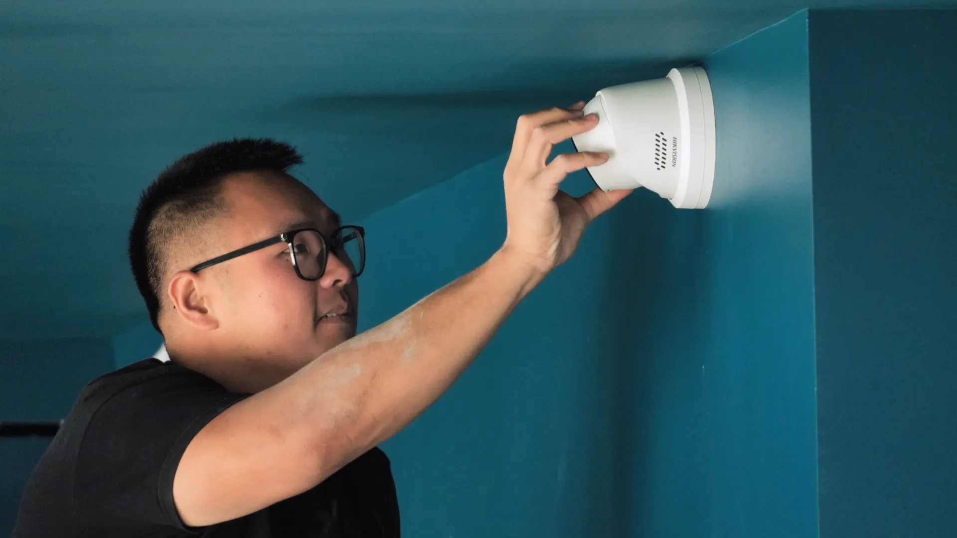 Technicien de SERELYS SÉCURITÉ en Vendée installant un détecteur de fumée blanc au plafond, expertise en solutions de sécurité