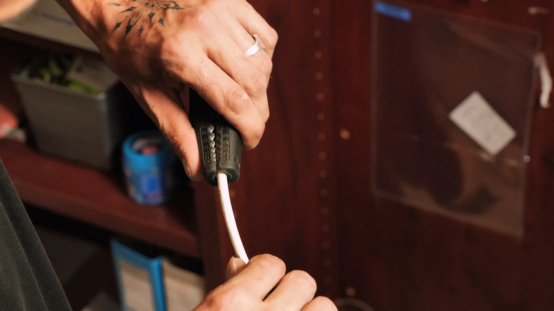 Technicien SERELYS SÉCURITÉ en Vendée manipulant un connecteur de câble réseau pour installation de vidéosurveillance professionnelle