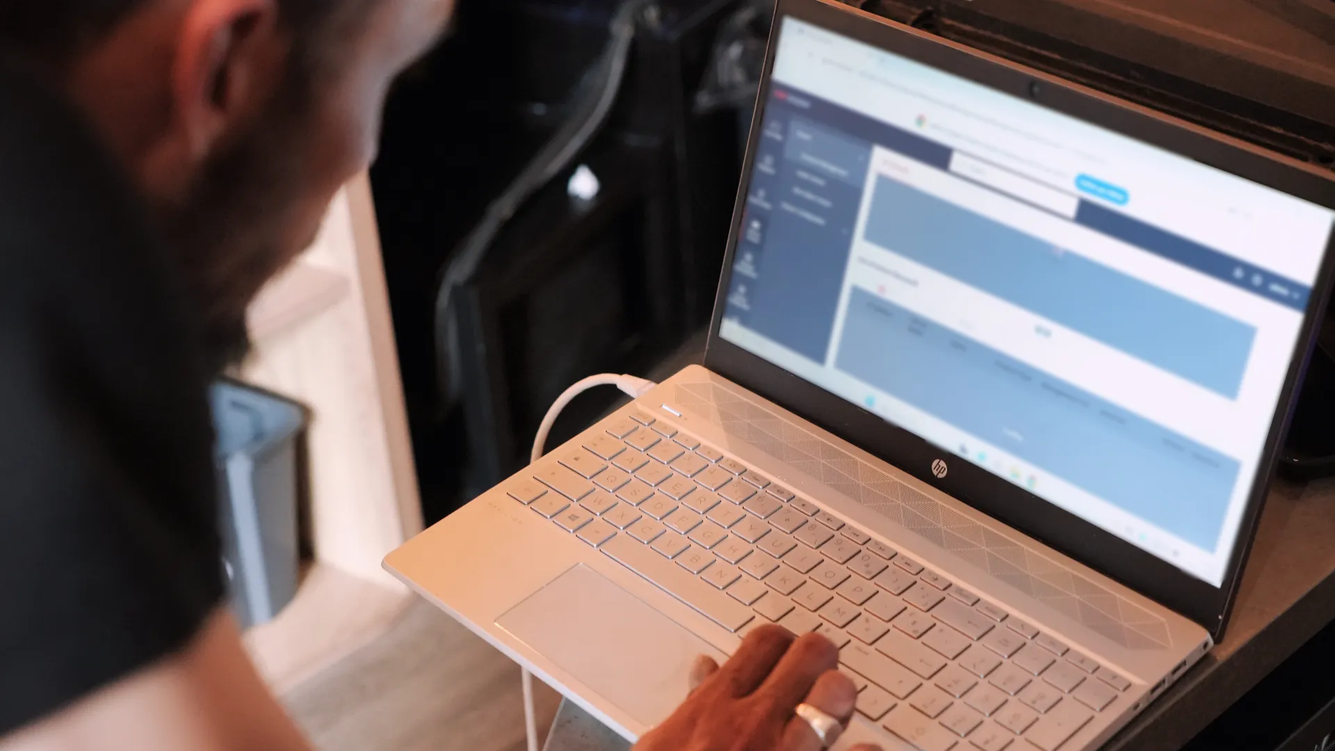 Technicien SERELYS SÉCURITÉ en Vendée consultant un logiciel de gestion d'alarme intrusion sur son ordinateur portable HP lors d'une intervention de sécurité premium