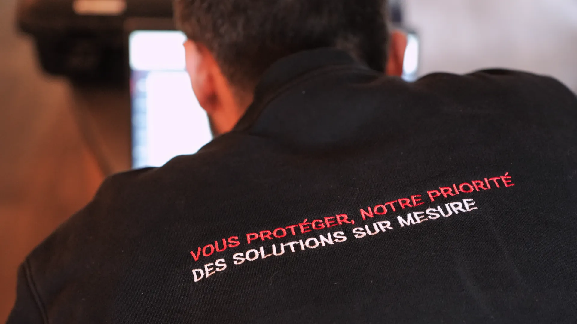 Équipe SERELYS SÉCURITÉ en Vendée portant un polo noir avec le slogan 'Vous protéger, notre priorité - Des solutions sur mesure', illustrant l'expertise en sécurité intrusion et alarme premium