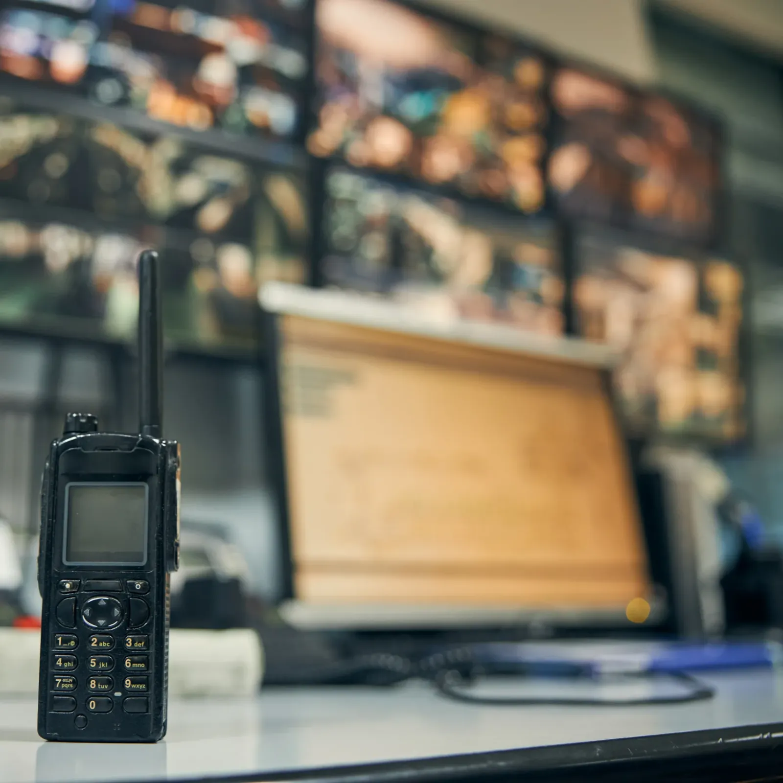 Talkie-walkie professionnel avec antenne en premier plan sur bureau, équipement de communication pour solutions de sécurité SERELYS SÉCURITÉ en Vendée