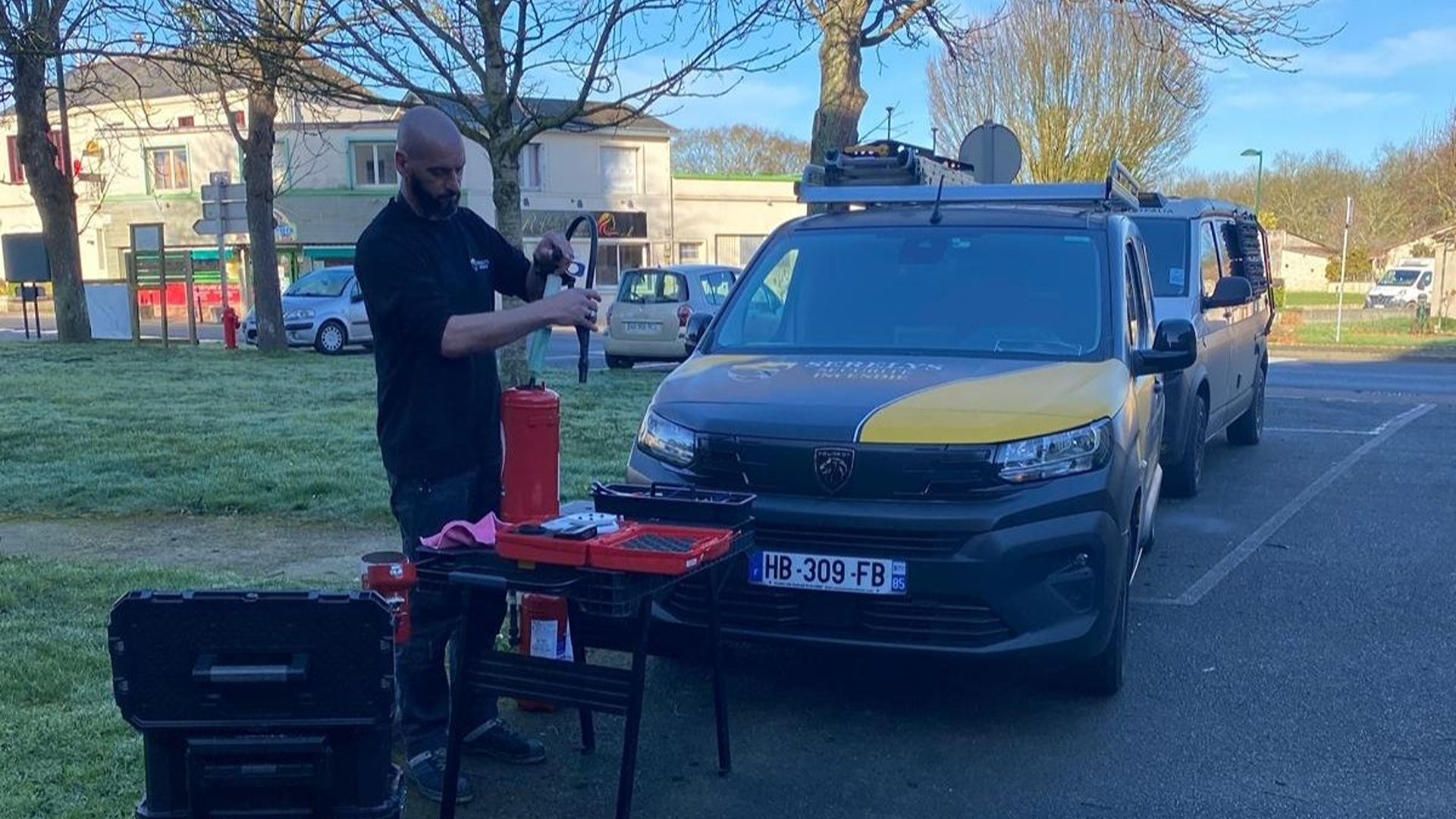 Technicien SERELYS SÉCURITÉ en Vendée effectuant une installation de vidéosurveillance sur un véhicule de patrouille équipé d'équipements de sécurité professionnels